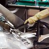 Mercedes AMG F1 W05 pipe attached to engine cover by a mechanic